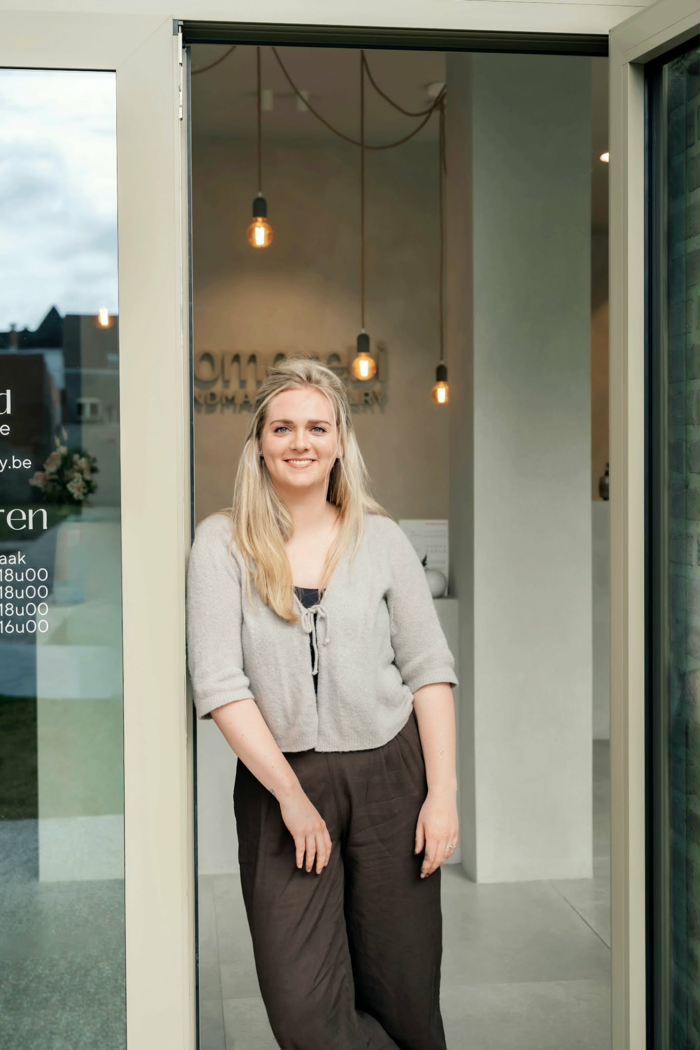 Goudsmid Laura Van Loocke in de deuropening van haar juwelierszaak in Deinze
