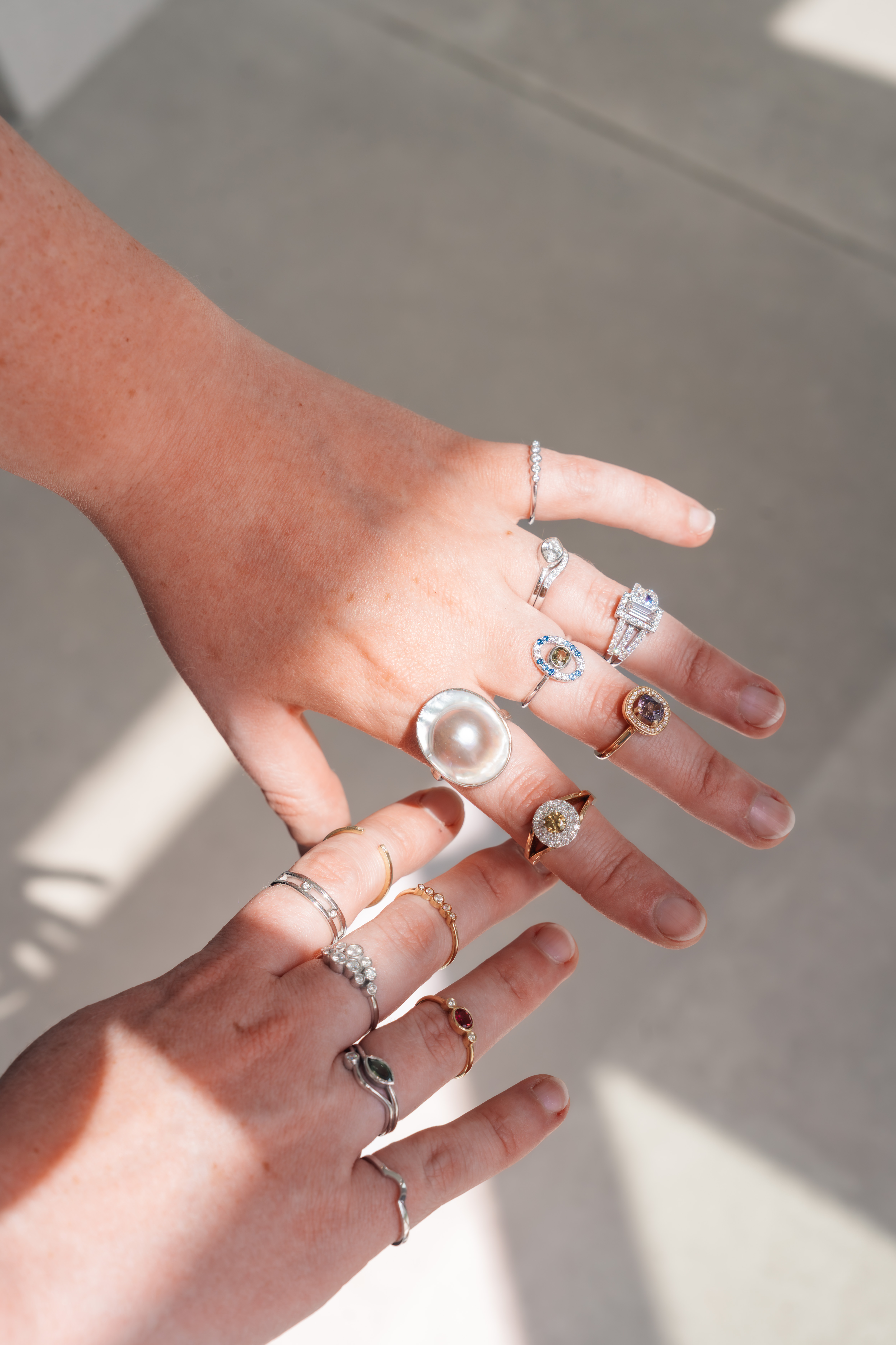 Twee handen in het zonlicht met handgemaakte ringen van juwelier Komorebi uit Deinze