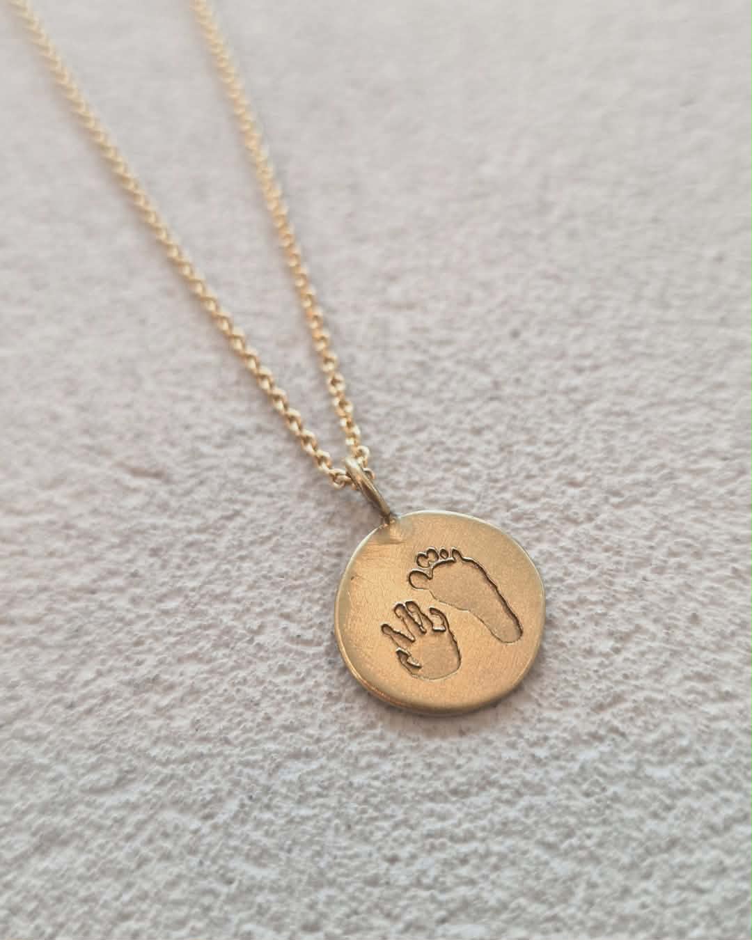 Gouden herinneringshanger met gegraveerde hand- en voetafdruk